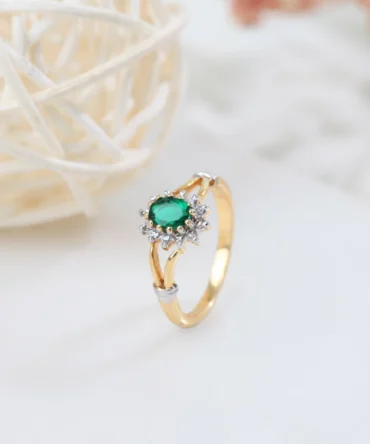 a gold ring with a green stone and diamonds