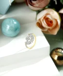 a gold ring with diamonds on a white surface