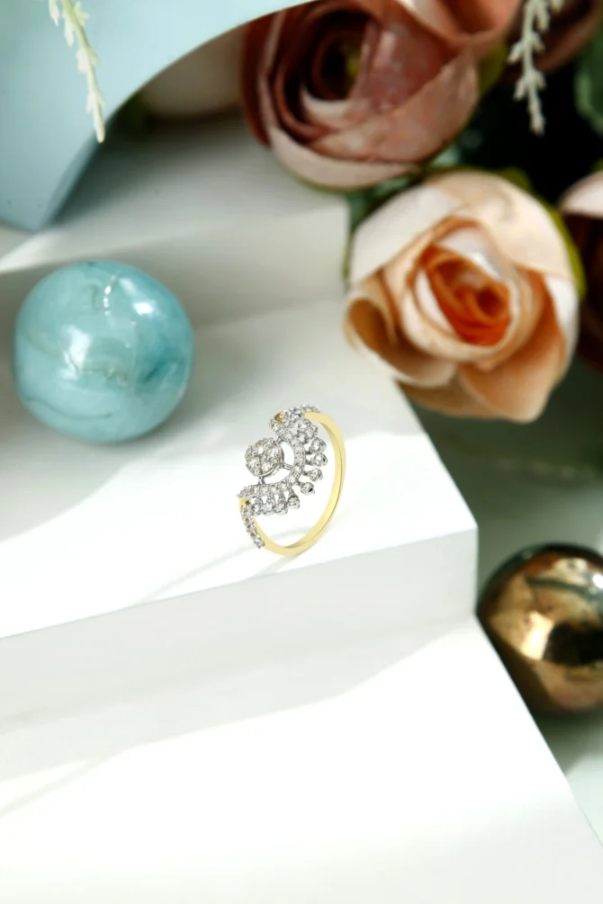 a gold ring with diamonds on a white surface