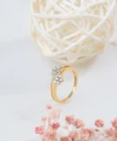 a gold ring with diamonds and a white ball of straw